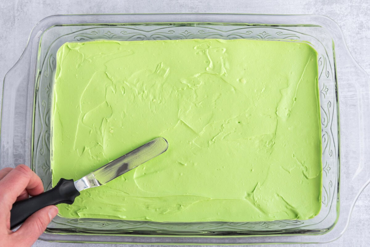 icing spatula spreading cream cheese mixture in a pan