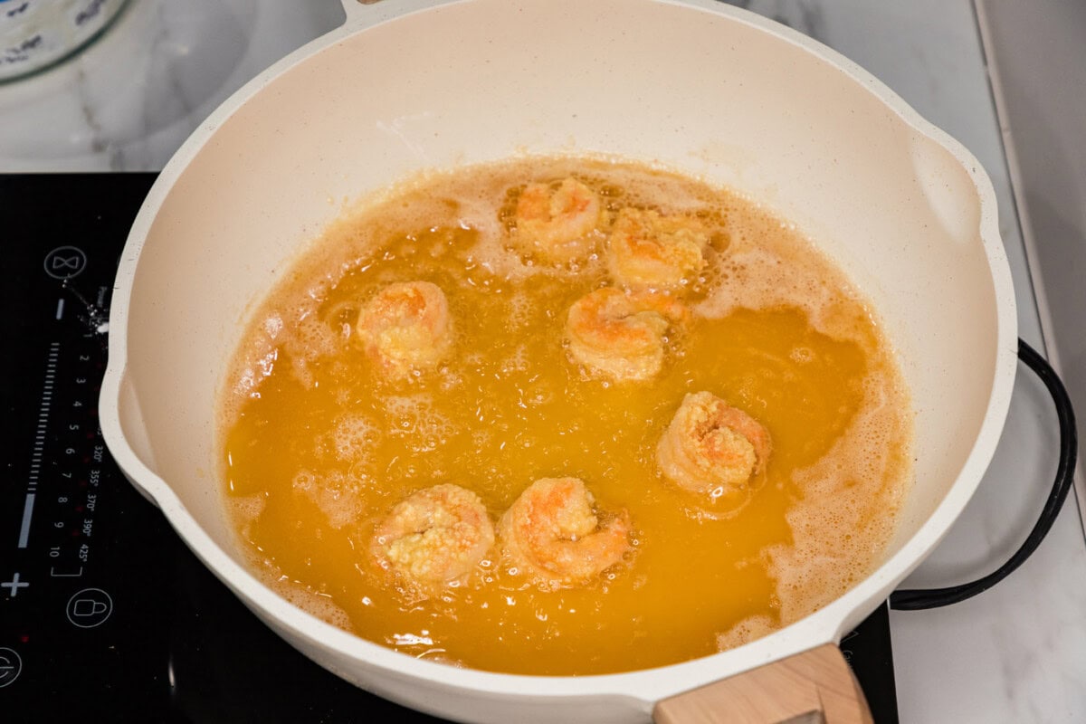 frying breaded shrimp in a skillet of oil