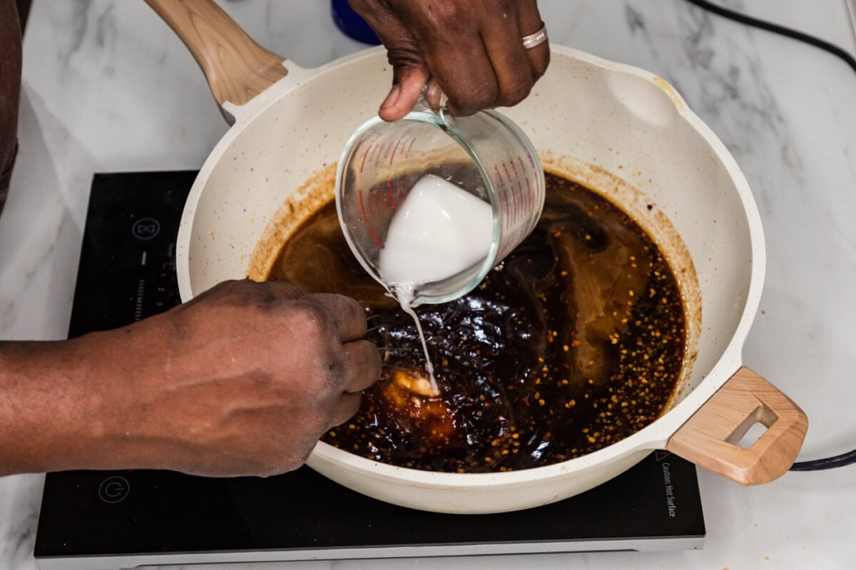 adding cornstarch slurry to Mongolian sauce in a skillet