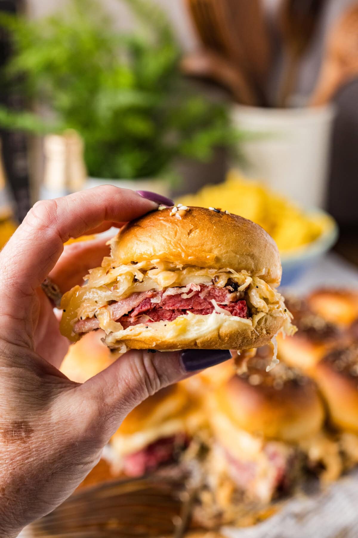 Hand holding a Reuben Slider