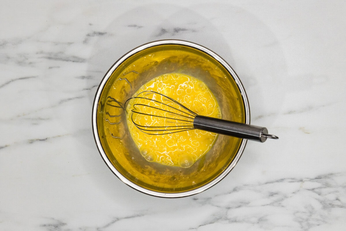 egg mixture in a bowl with a whisk