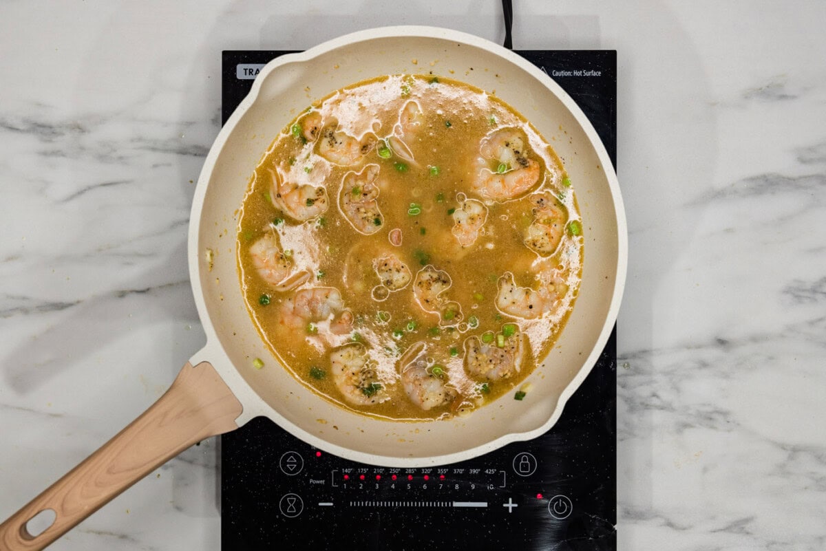 chicken base added to shrimp in a skillet
