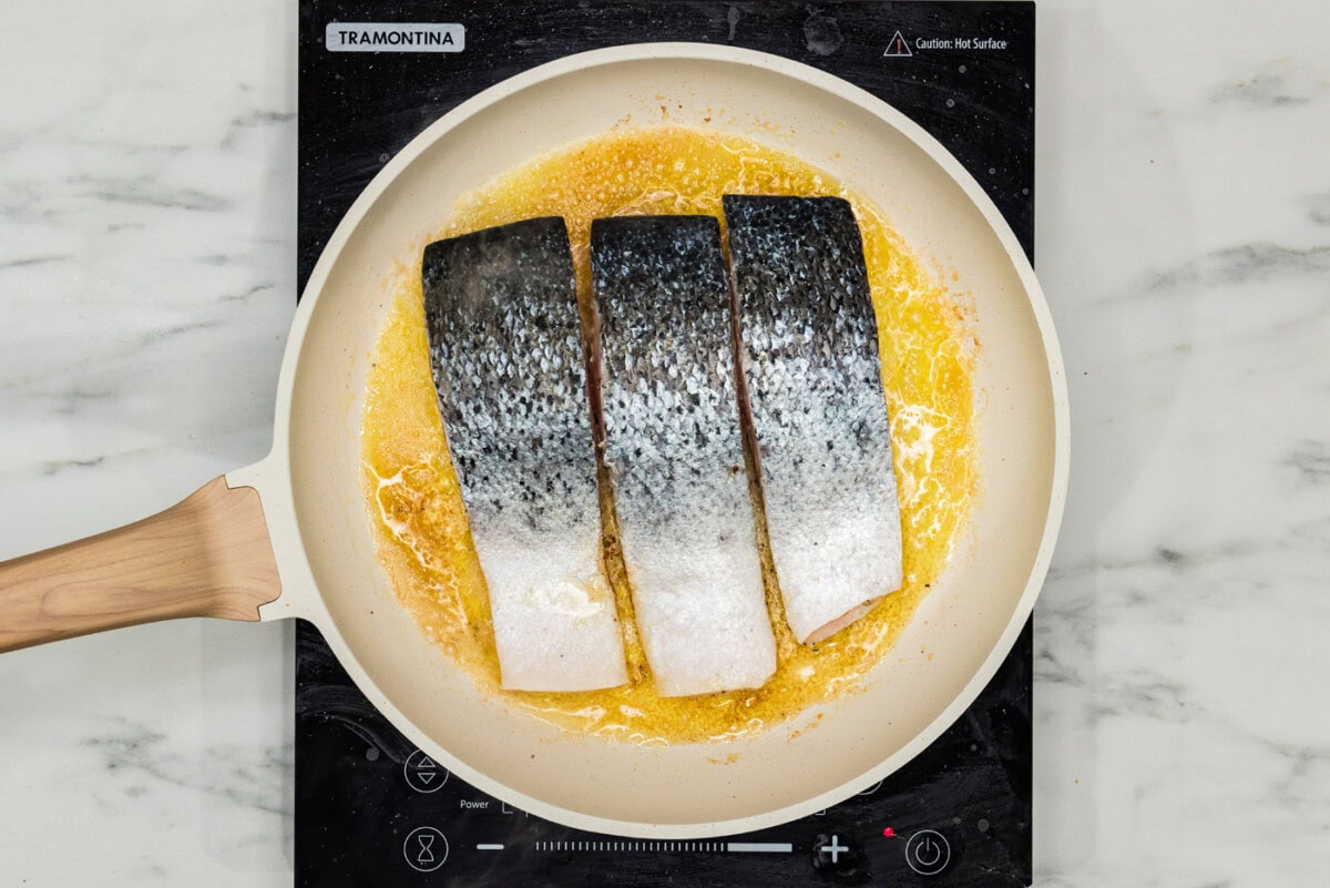 salmon filets in a skillet skin side up
