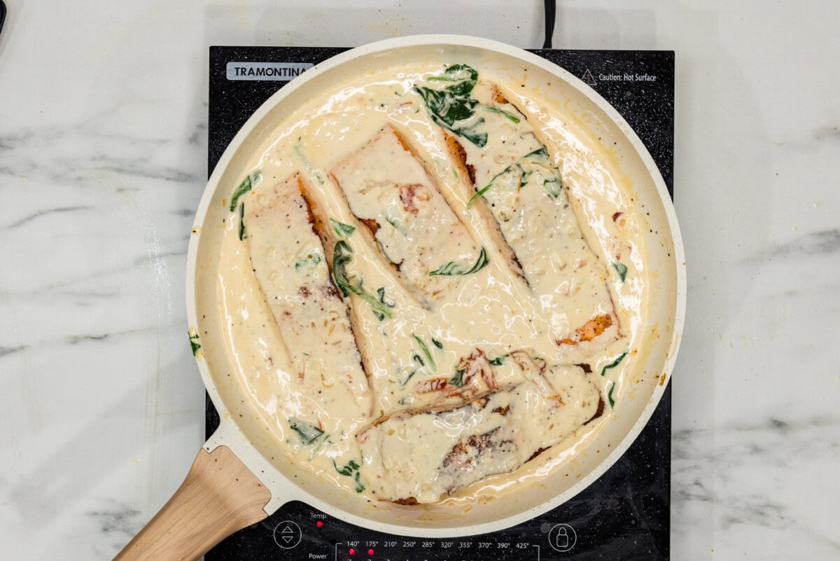salmon filets in a skillet with cream sauce