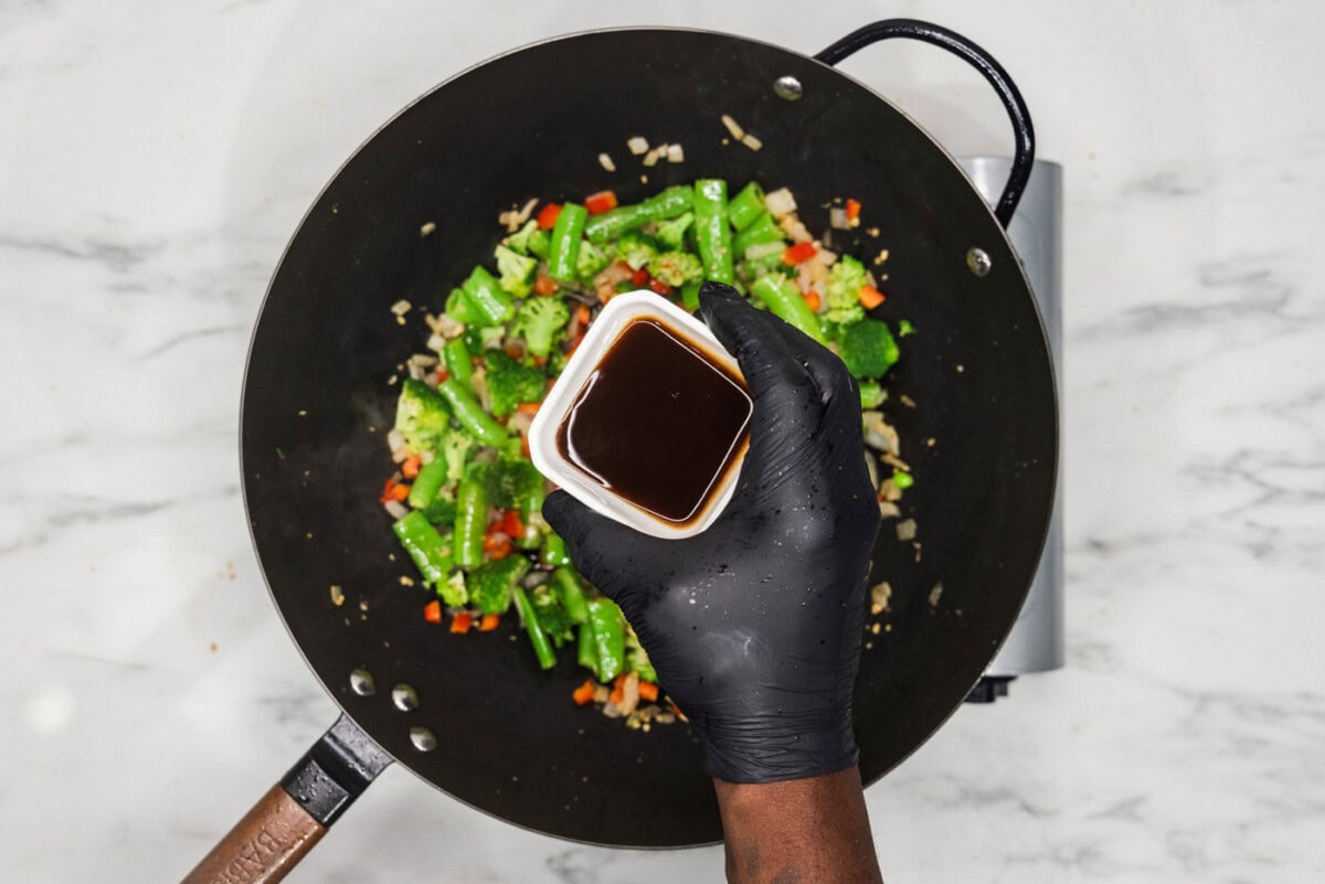 Oyster sauce over a skillet over vegetables