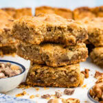 Close up photo of a stack of Brown Butter Chocolate Toffee Blondies with a bite taken out of the top one