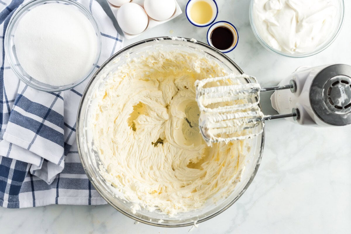beaters with cream cheese mixture in a bowl