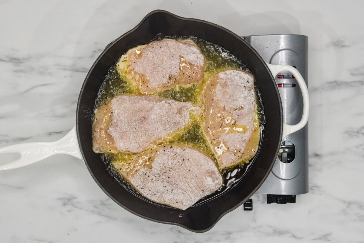 dredged chicken cooking in hot oil
