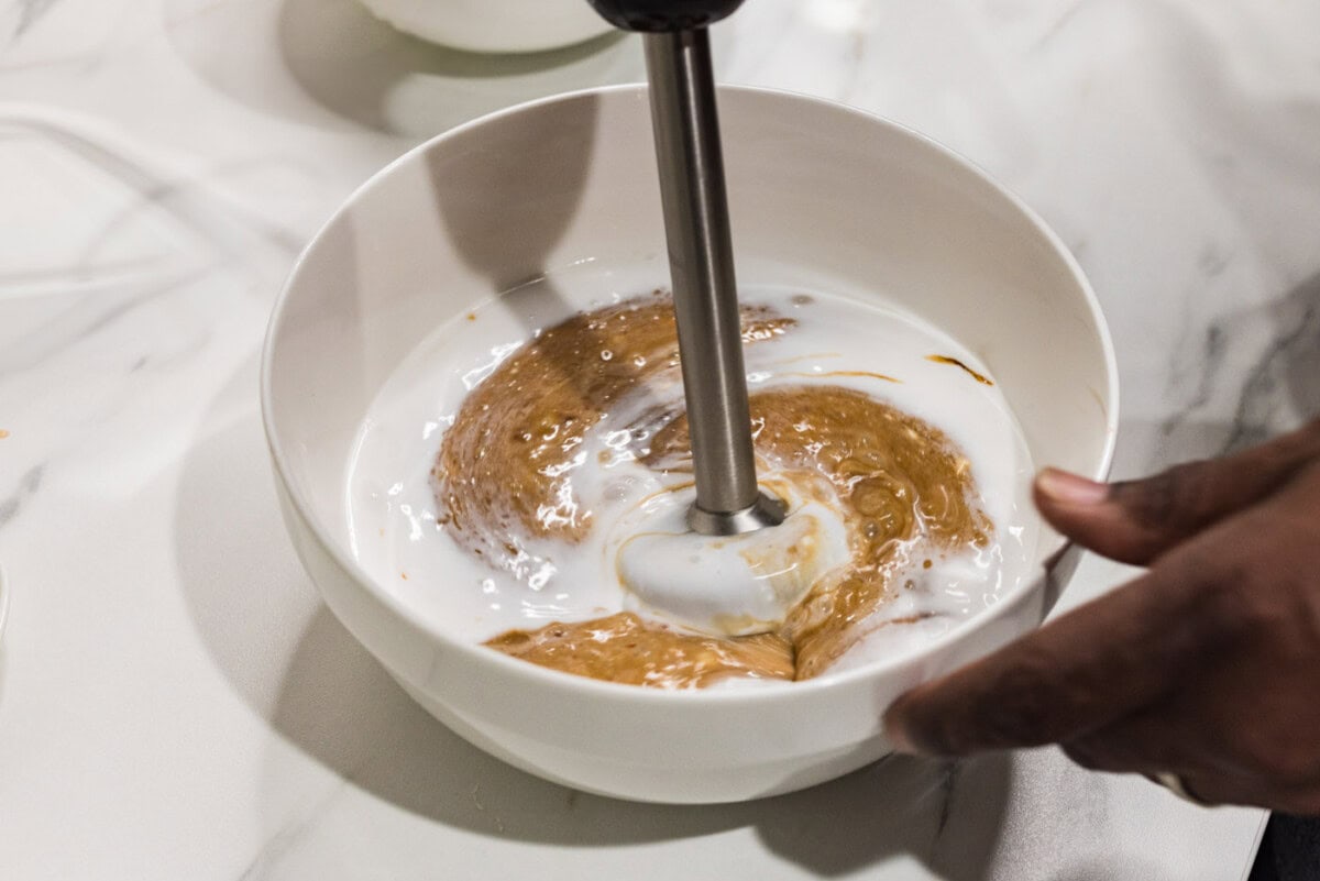 blitzing coconut sauce ingredients with an immersion blender