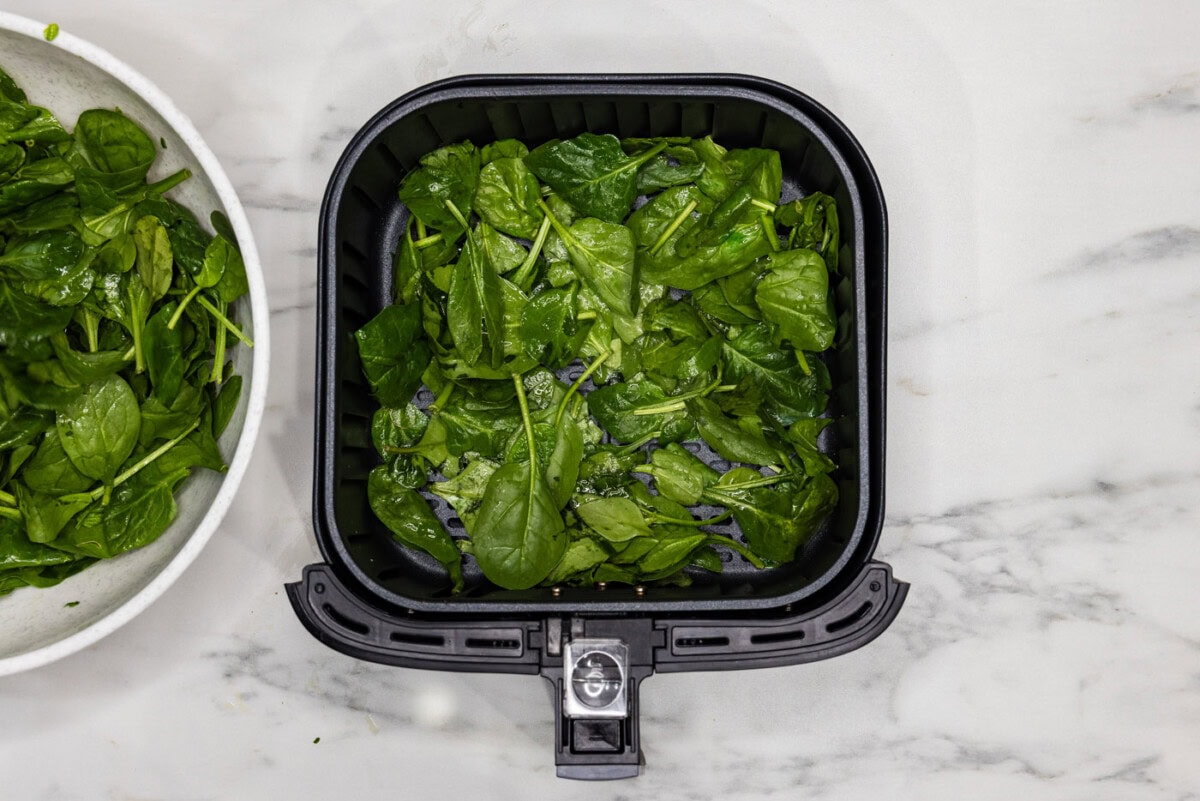 spinach in an air fryer basket