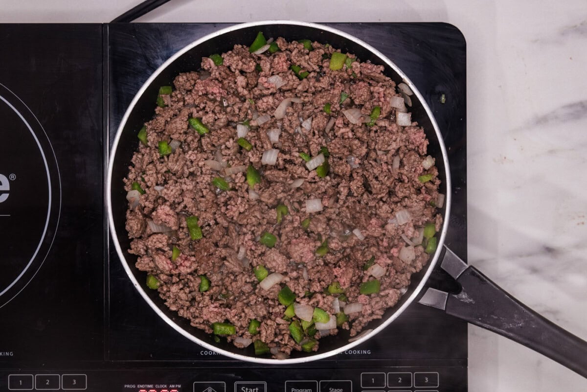 browned ground beef with onion and bell pepper in a skillet