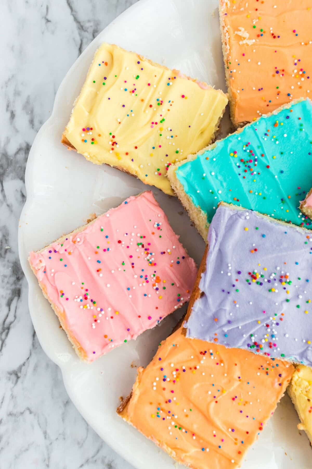 Close up photo of half a plate of Frosted Sugar Cookie Bars