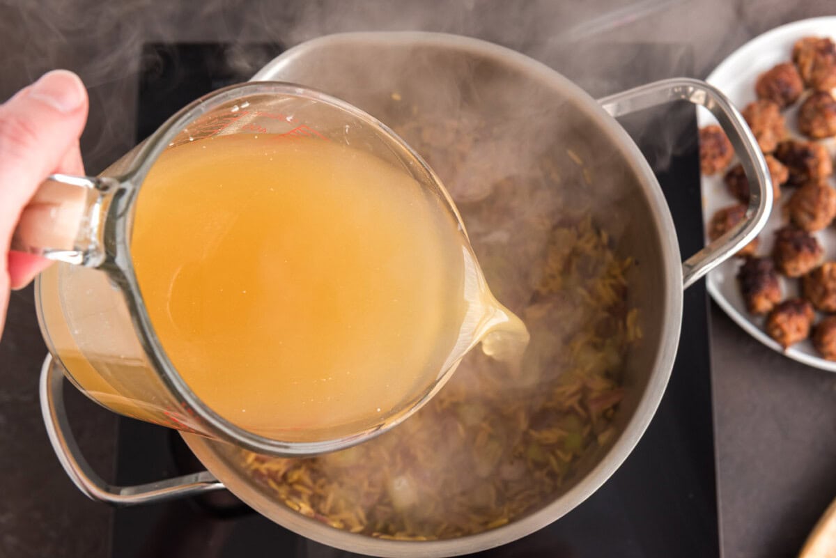 pouring chicken broth into stock pot