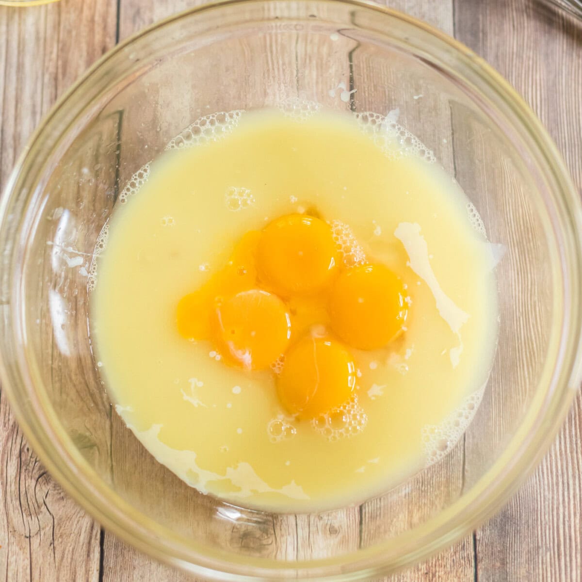 egg yolks in bowl with sweetened condensed milk