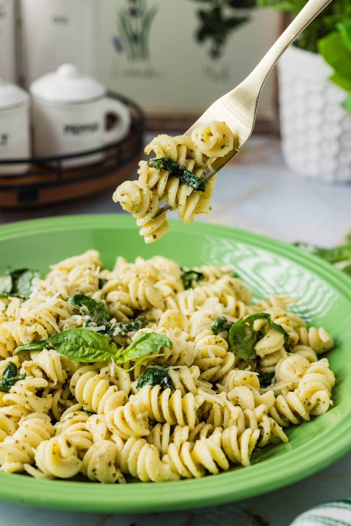 Forkful of Pesto Pasta held above a plate of Pesto Pasta