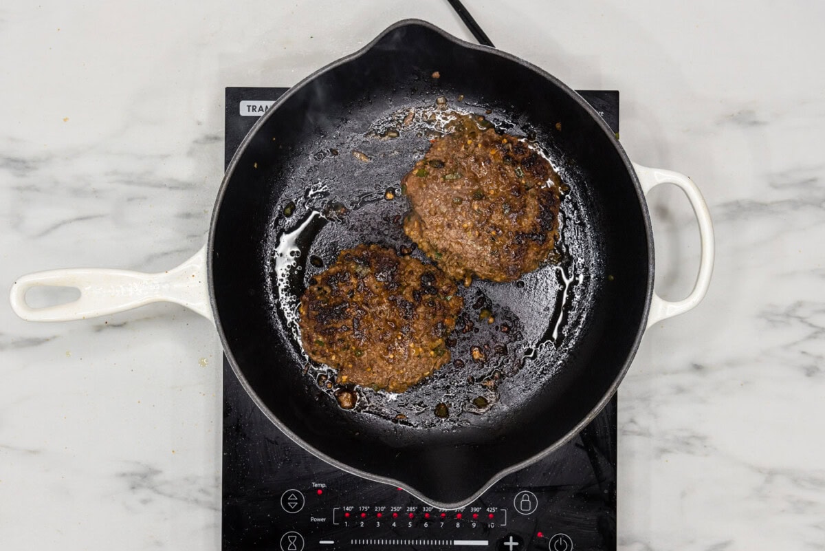 cooked taco burger patties in a skillet