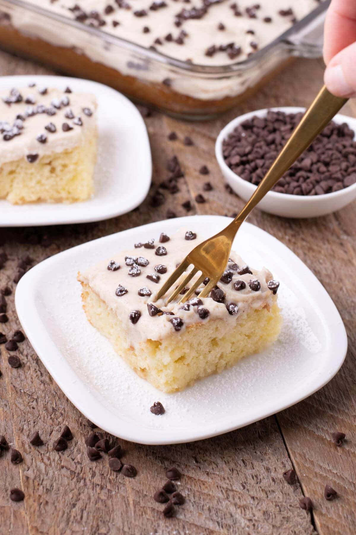 Fork cutting into a slice of Cannoli Poke Cake