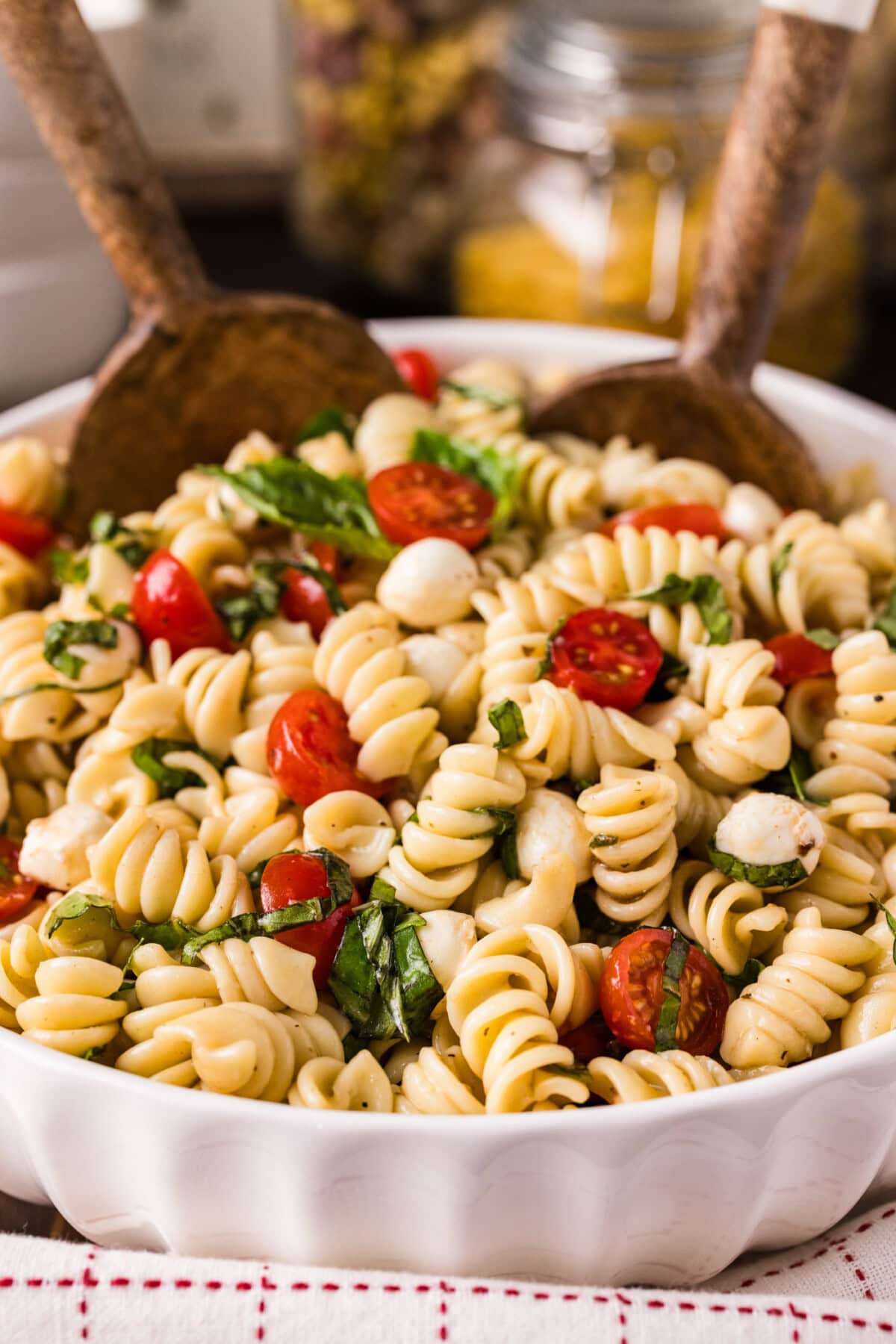 Two spoons in a bowl of Caprese Pasta Salad