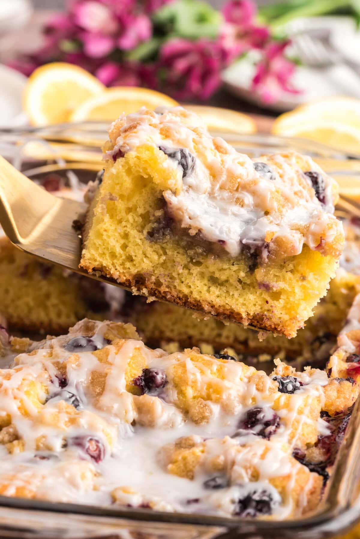 Slice of Glazed Lemon Blueberry Cake being lifted out of the dish