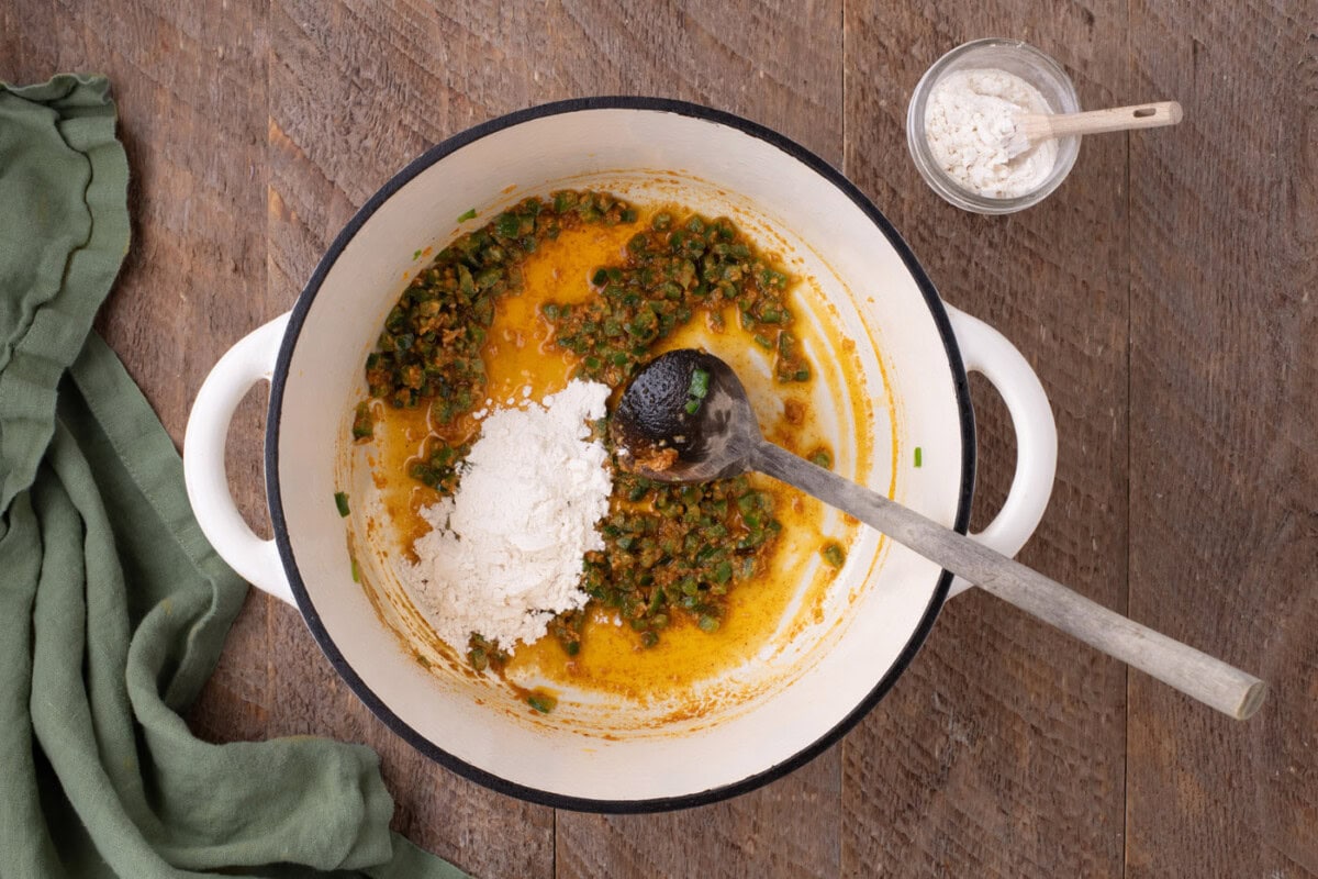 adding spices to pot with jalapenos and butter
