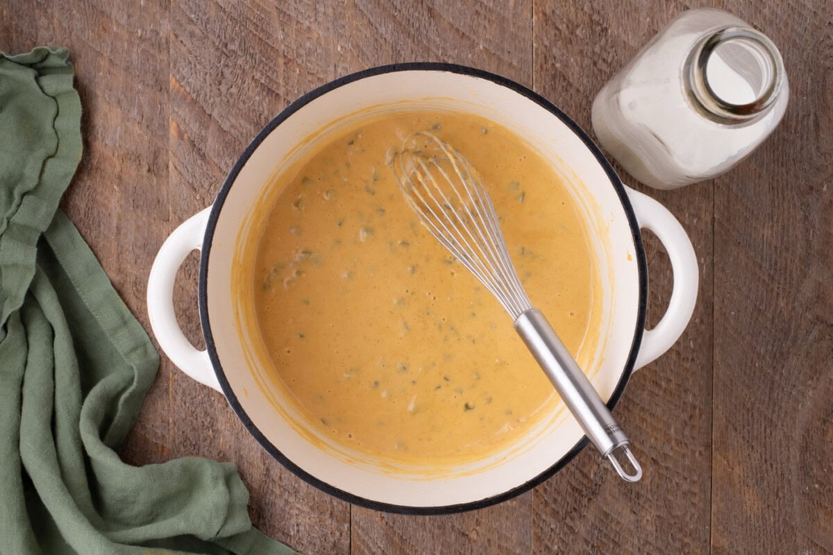 cheese sauce in a pot with a whisk