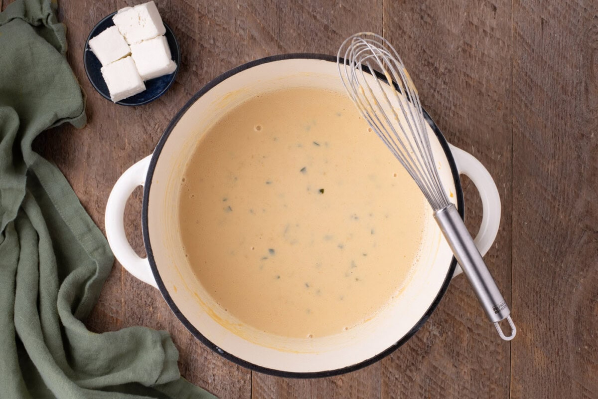 jalapeno cheese sauce in a pan with a whisk