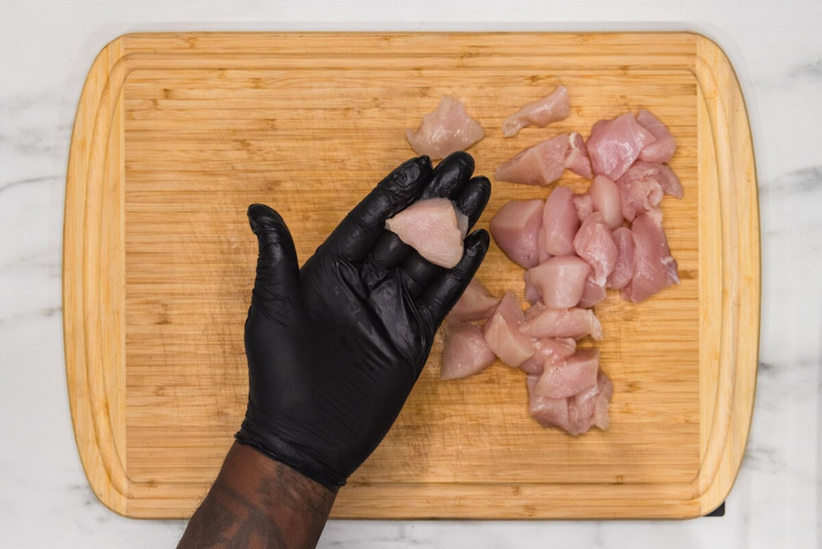 hand holding cubed chicken breast