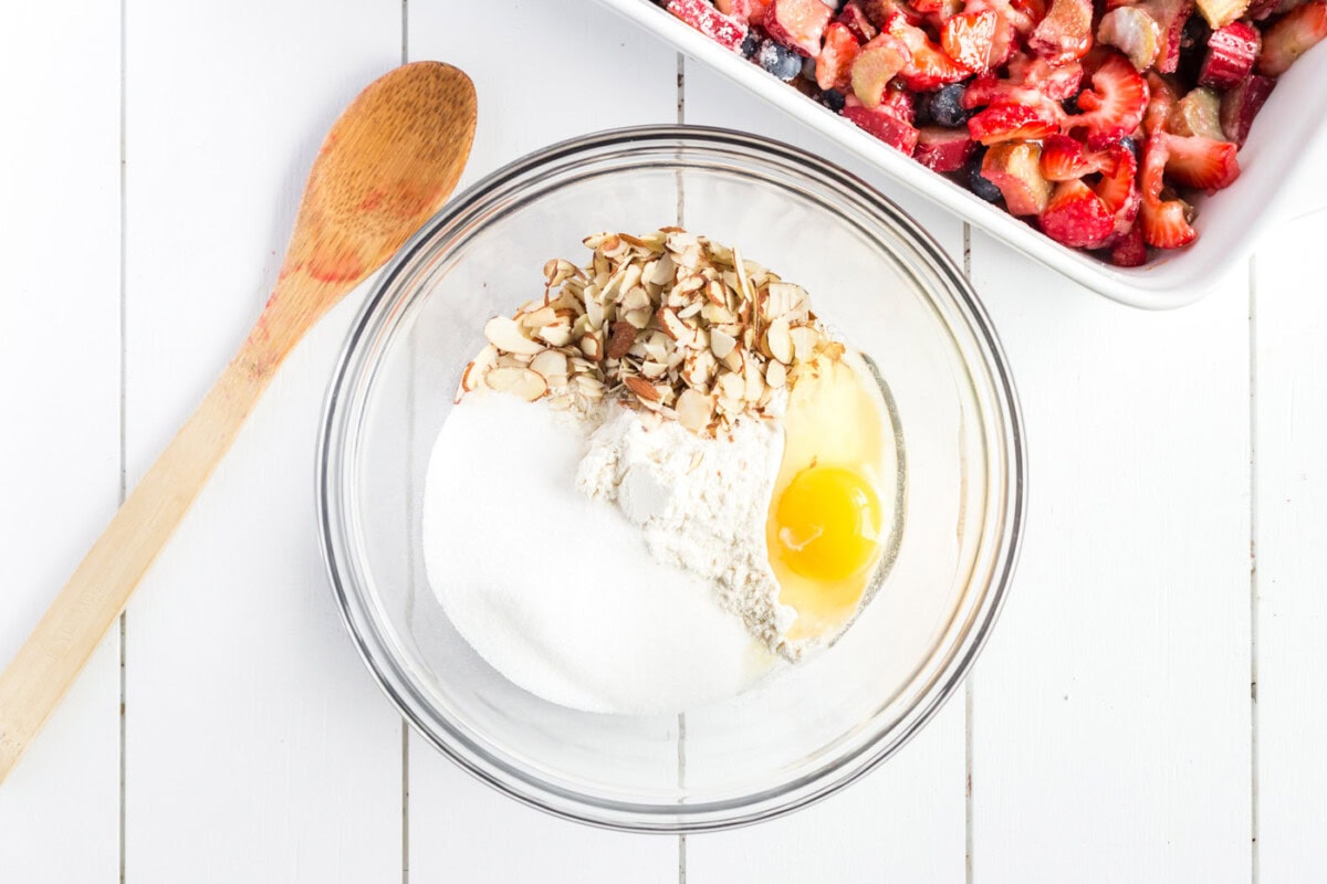 Flour, sugar, salt, sliced almonds and egg in a bowl