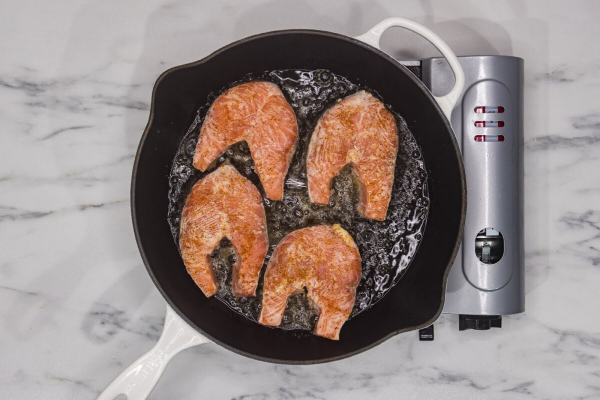 salmon steaks cooking in a skillet