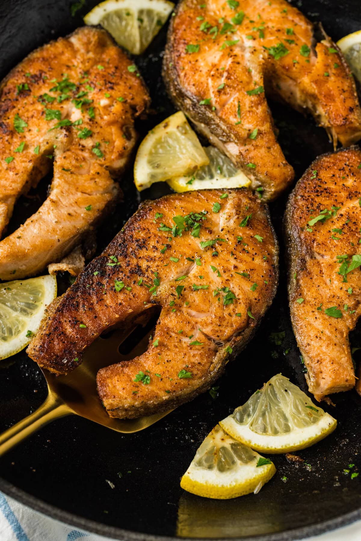 Close up photo of a Salmon Steak on a spatula resting in a skillet
