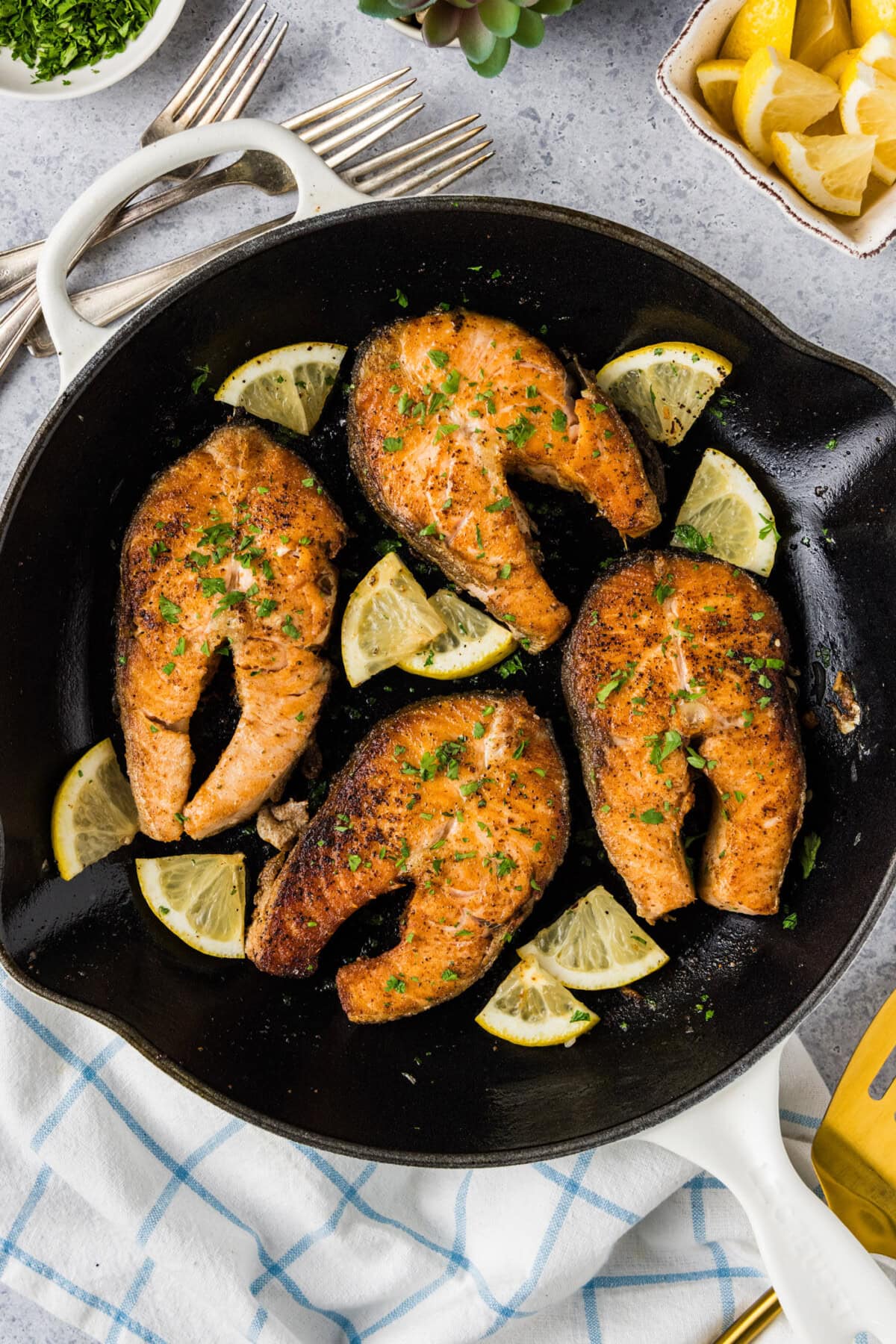 Skillet of Salmon Steaks and lemon wedges