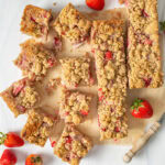 Strawberry Rhubarb Crumble Bars resting on parchment paper