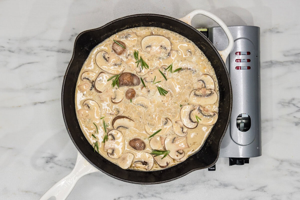 creamy scallopini sauce in a skillet with mushrooms