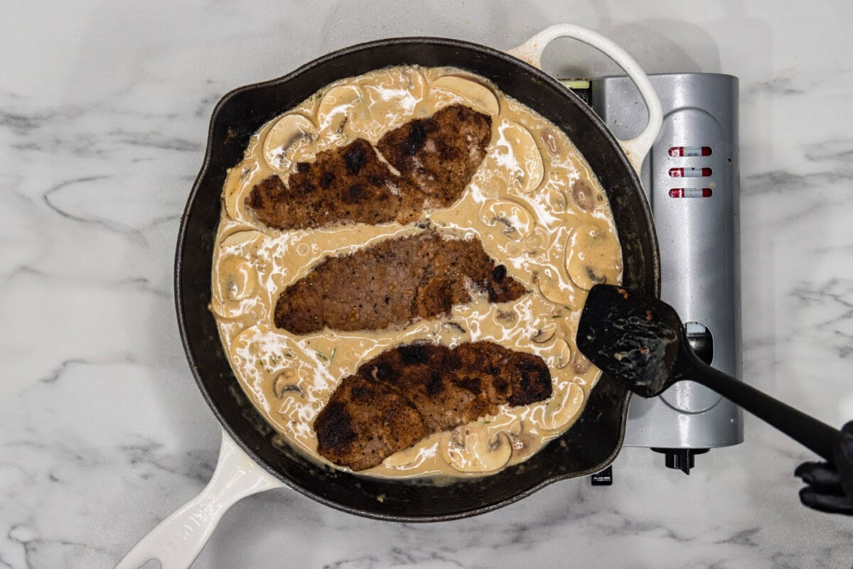 veal cutlets in cream and mushroom sauce in a skillet