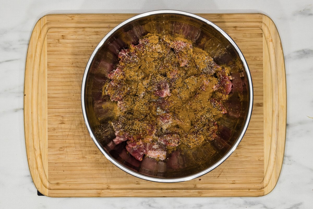 beef cubes in a bowl with seasonings