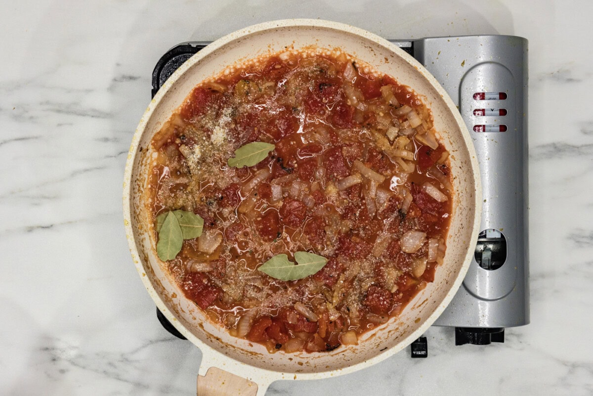 tomatoes, wine, and bay leaves added to skillet