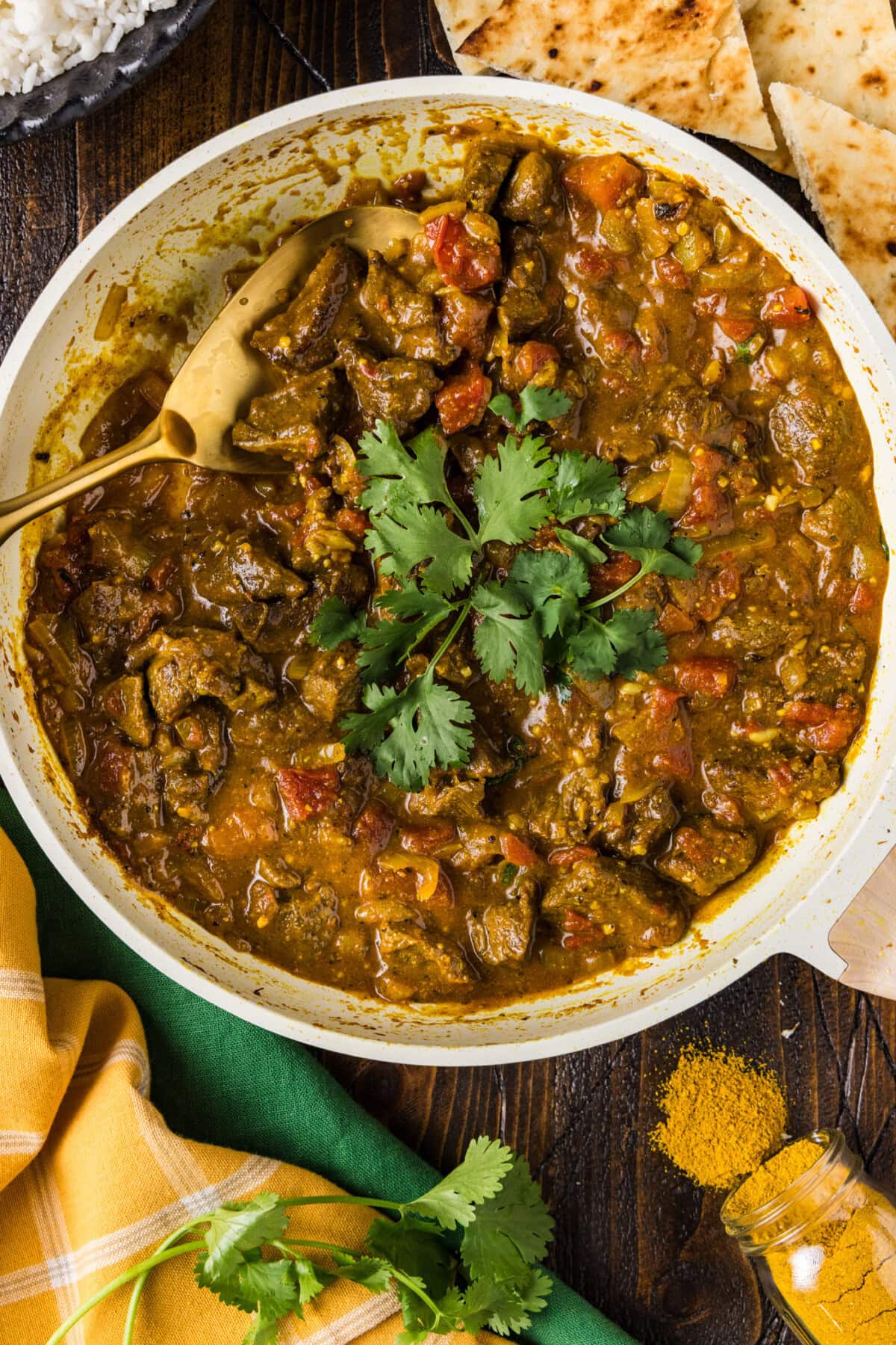 Skillet of Beef Curry with a spoon in it