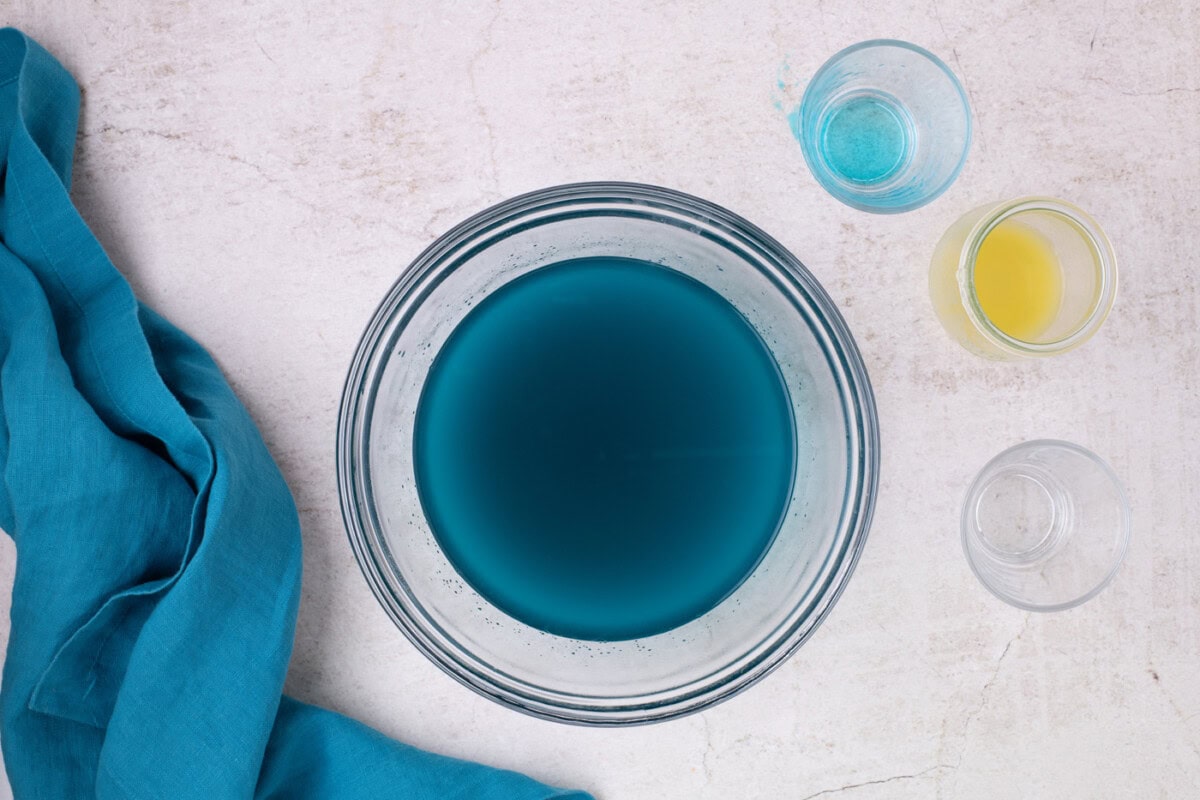 blue jello powder mixed with water in a bowl