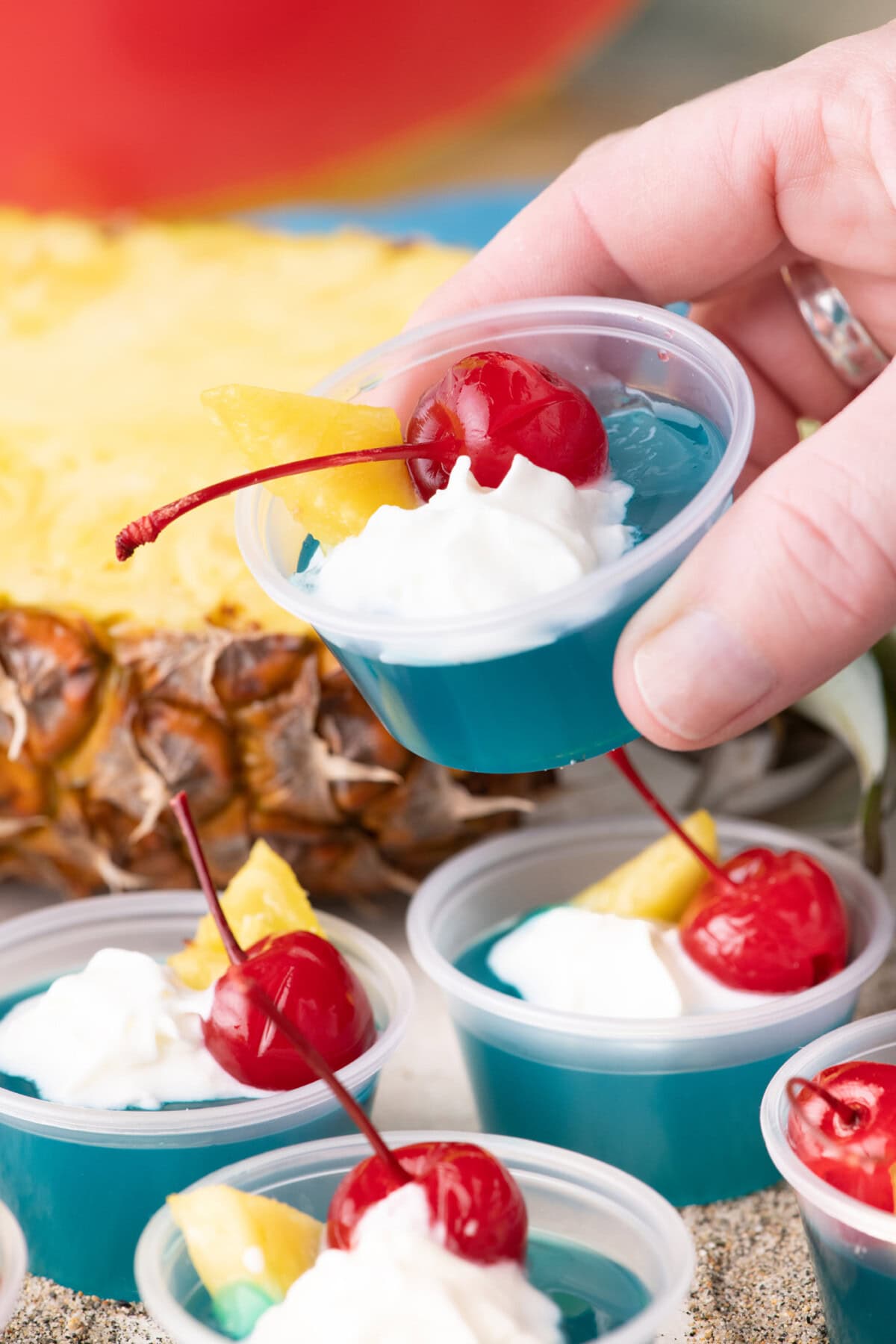 Hand holding up a Blue Hawaiian Jello Shot