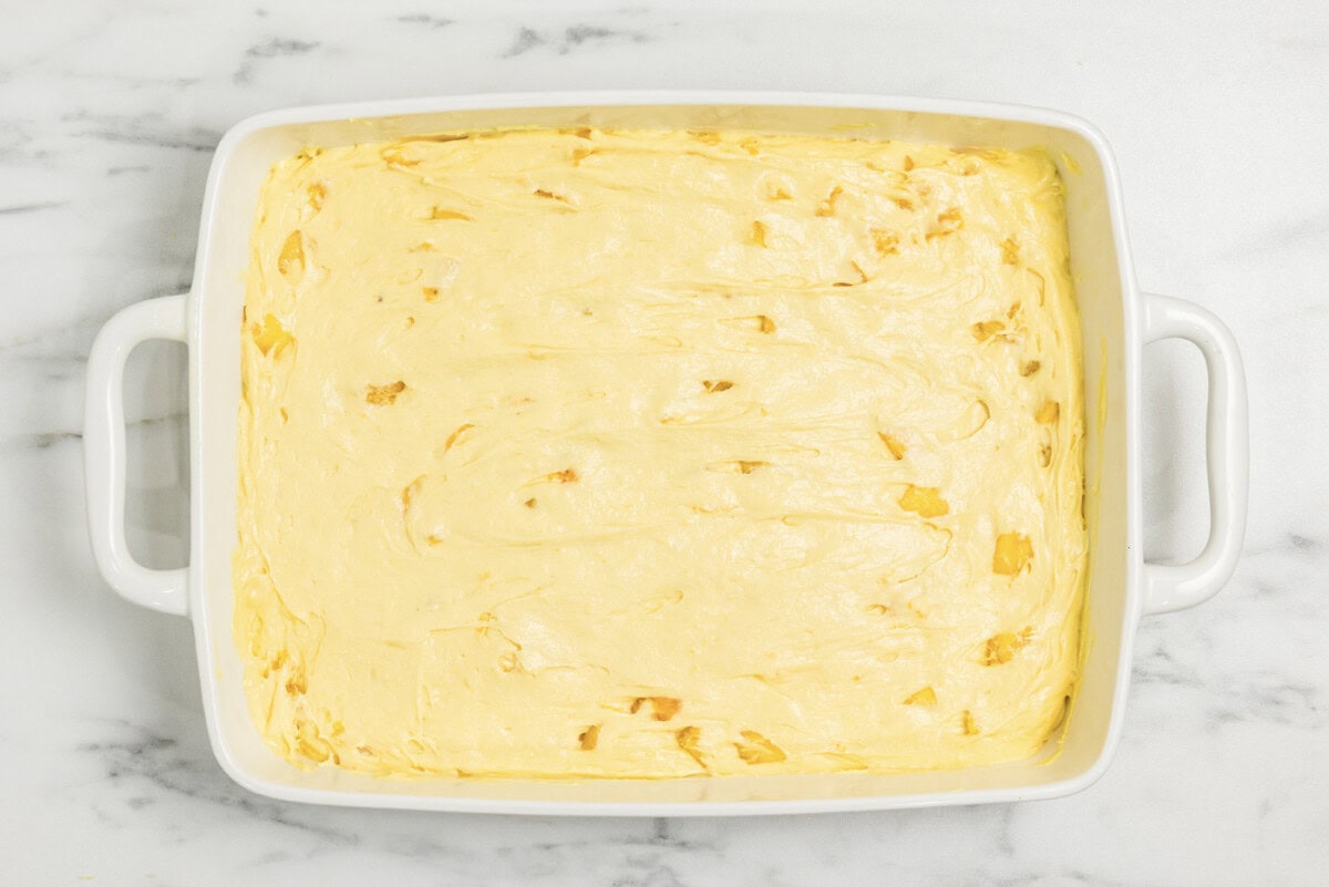 peach cake batter in a baking dish