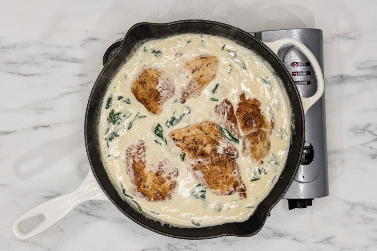 chicken florentine in a skillet with cream sauce