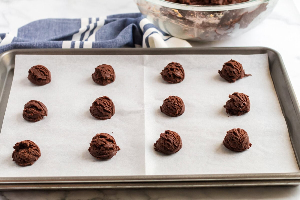 Chocolate Peanut Butter Cookie dough balls on a parchment lined baking sheet