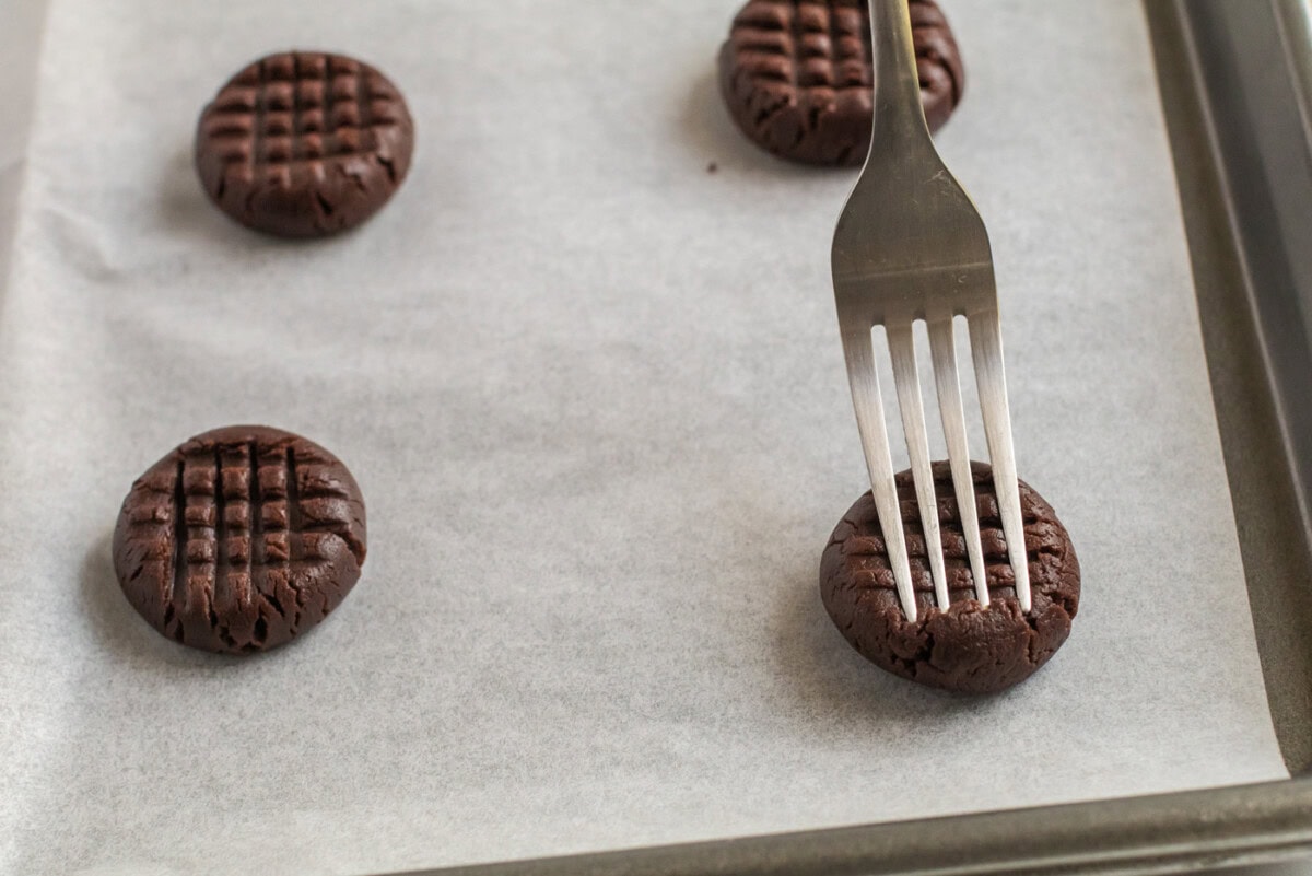 Fork flattening a Chocolate Peanut Butter Cookie dough ball