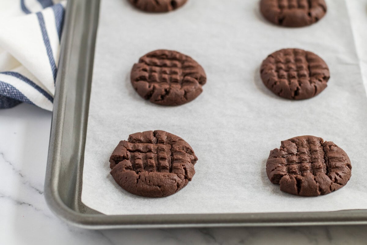 Freshly baked Chocolate Peanut Butter Cookies on a parchment lined baking sheet
