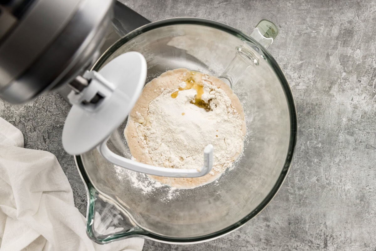 dough ingredients in a bowl with a dough hook