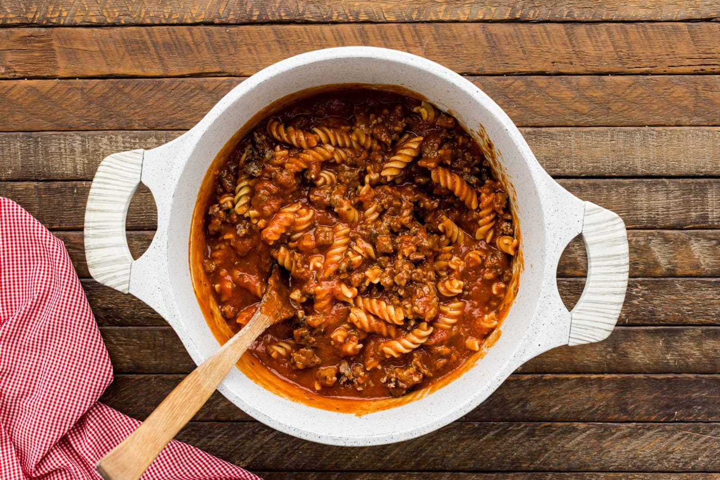 rotini pasta with marinara and sausage in a mixing bowl