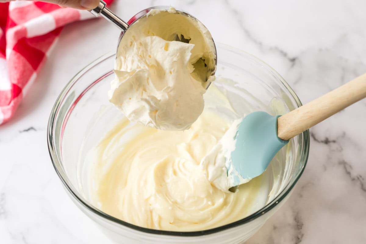 Cool whip being added to the cream cheese mixture