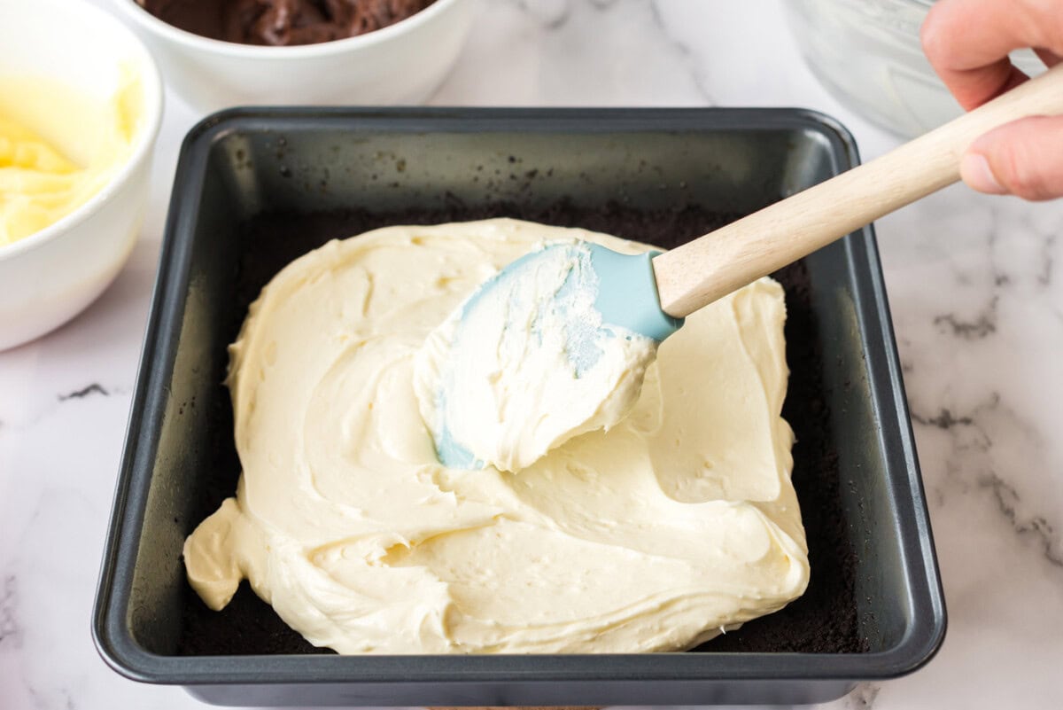 Cream cheese mixture being spread over the crust