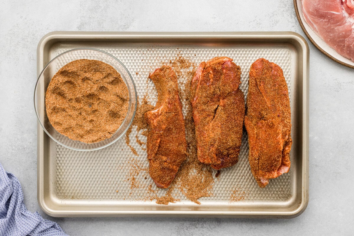 country style ribs rubbed with seasonings on a baking sheet