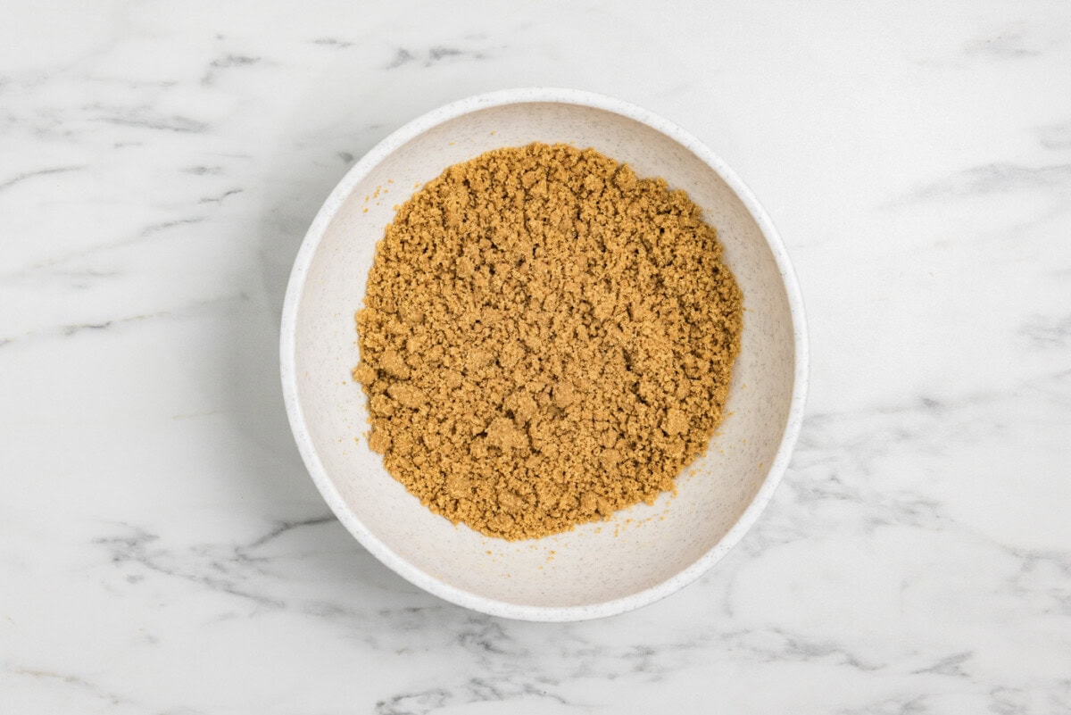 graham cracker crumbs mixed with melted butter in a bowl